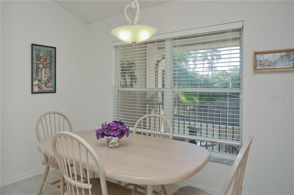 5270 Hyland Hills Avenue, Unit 1722 Sarasota, FL 34241 - Photo 21 of 30 a view of a dining room with furniture and chandelier