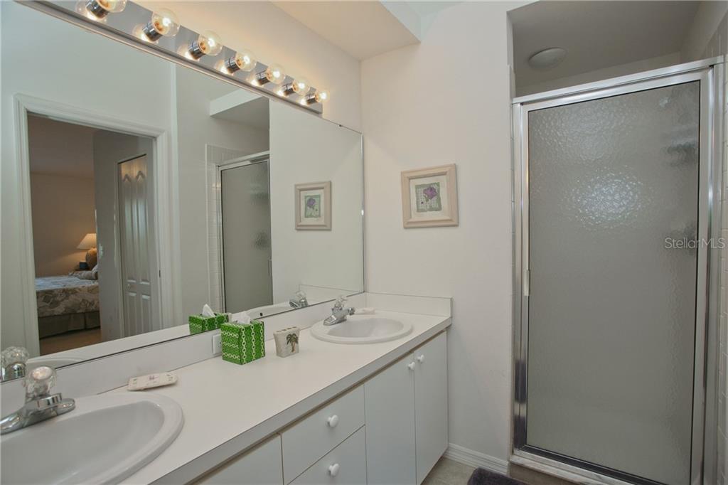 5270 Hyland Hills Avenue, Unit 1722 Sarasota, FL 34241 - Photo 24 of 30 a bathroom with a granite countertop sink and a mirror