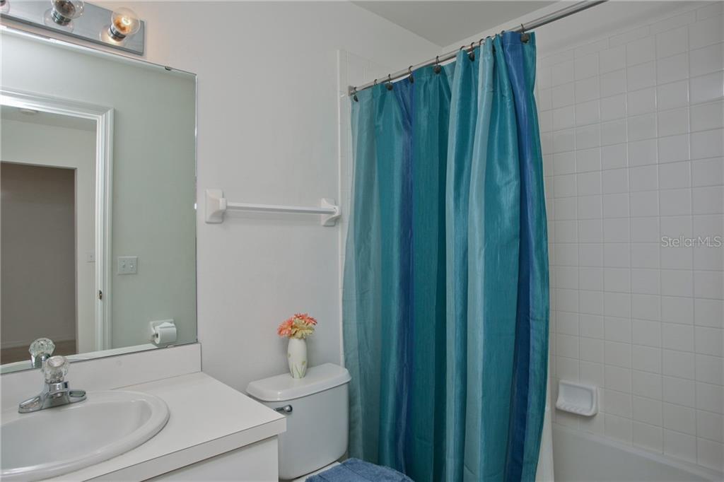 5270 Hyland Hills Avenue, Unit 1722 Sarasota, FL 34241 - Photo 26 of 30 a bathroom with a sink toilet and shower