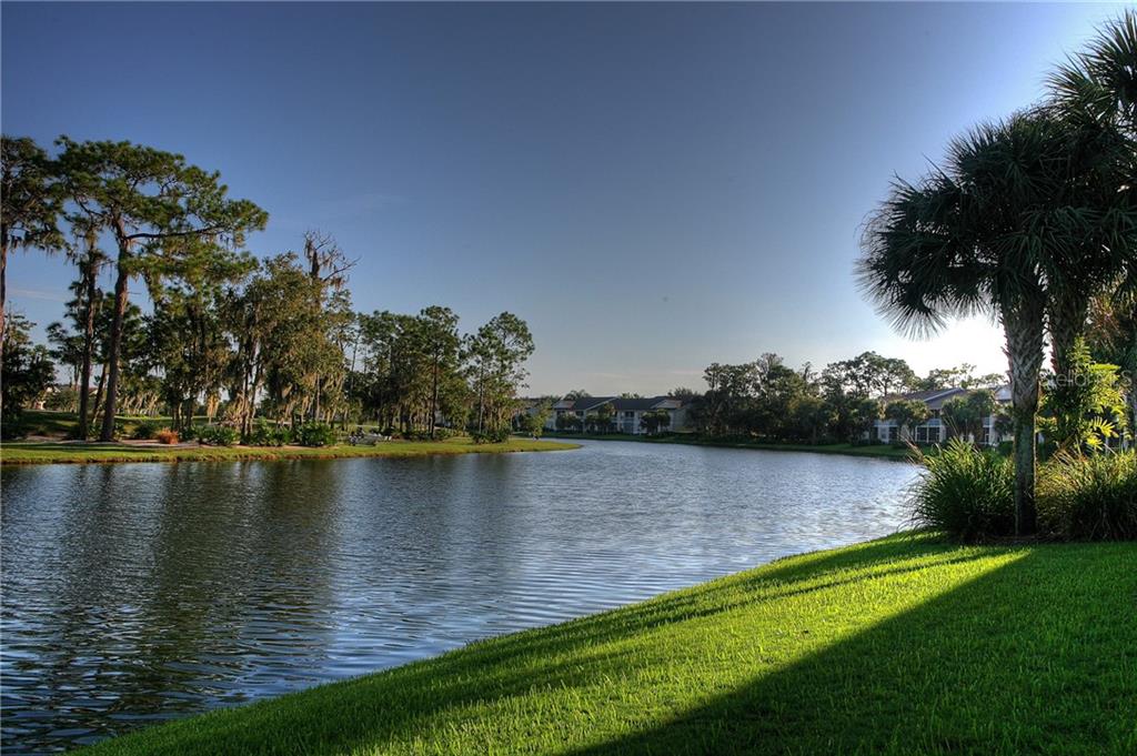 5270 Hyland Hills Avenue, Unit 1722 Sarasota, FL 34241 - Photo 29 of 30 a view of a lake with houses in the back