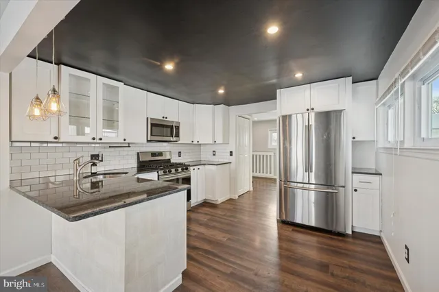 a kitchen with stainless steel appliances a refrigerator sink and microwave