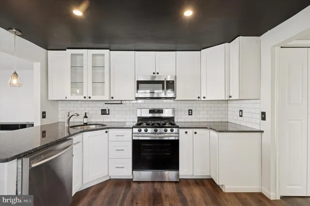 a kitchen with granite countertop white cabinets and white appliances