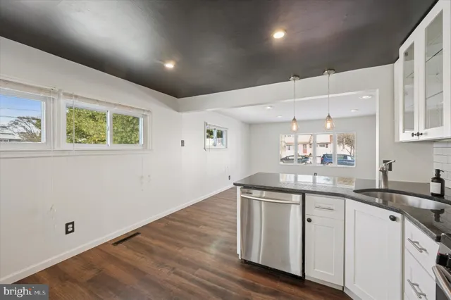a kitchen with a sink cabinets and wooden floor