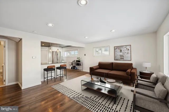 a living room with furniture a rug and a table