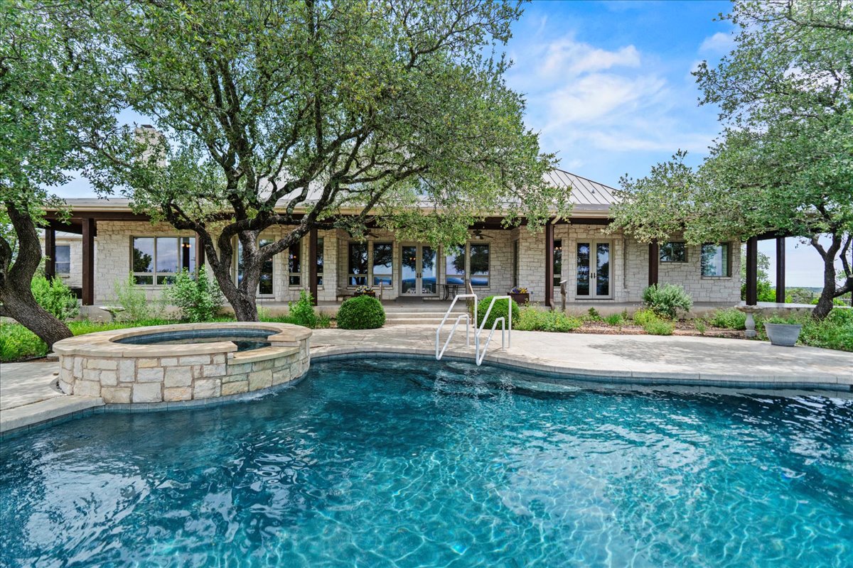 167 Wimberley Ranch Drive Wimberley, TX 78676 - Photo 4 of 40 a front view of a house with a garden and fountain