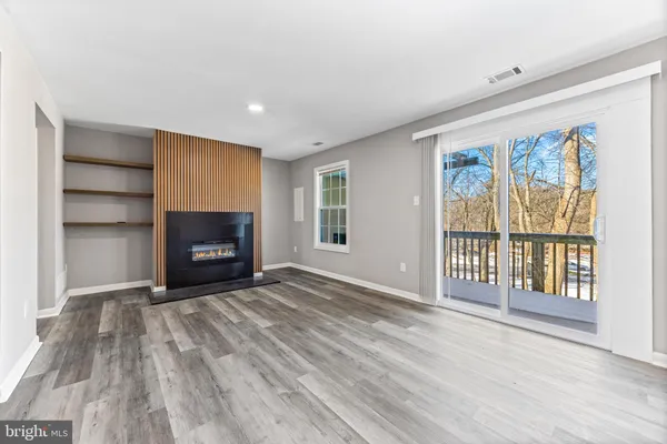 a view of an empty room with a fireplace and a window