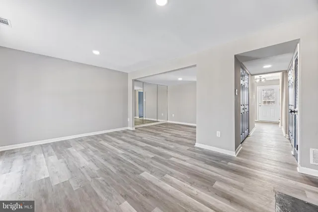 a view of empty room with wooden floor