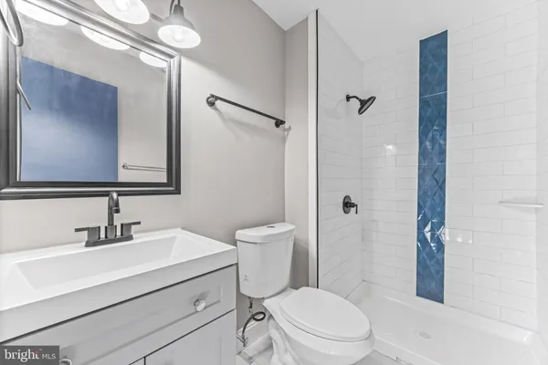 a bathroom with a sink a mirror a toilet and shower