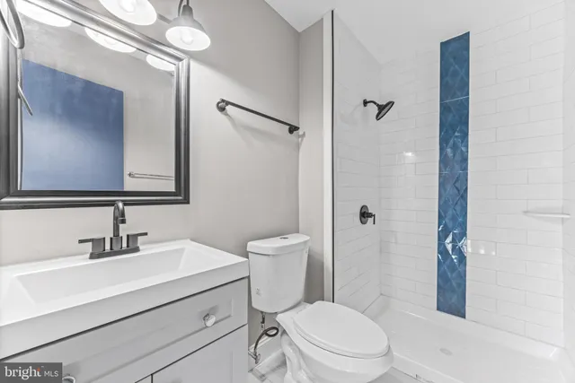 a bathroom with a sink a mirror a toilet and shower