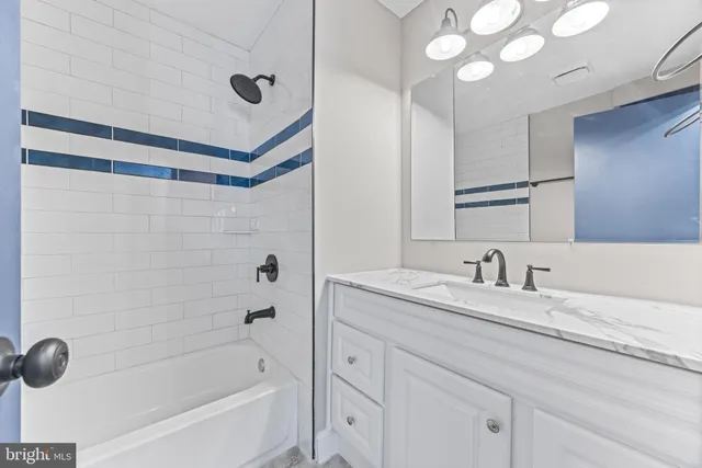 a bathroom with a granite countertop sink a mirror a shower and a bathtub