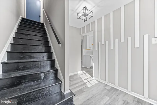 a view of a hallway with wooden floor and staircase