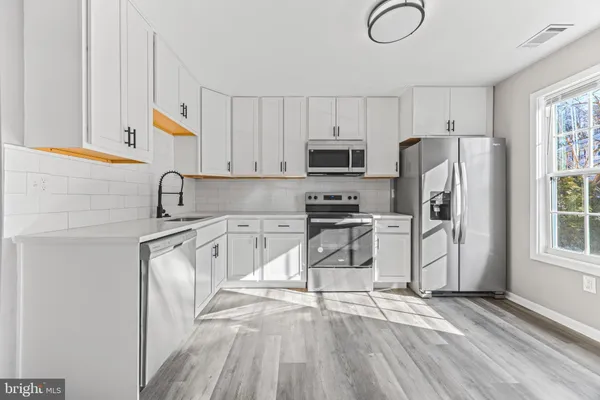 a kitchen with stainless steel appliances a refrigerator sink and cabinets