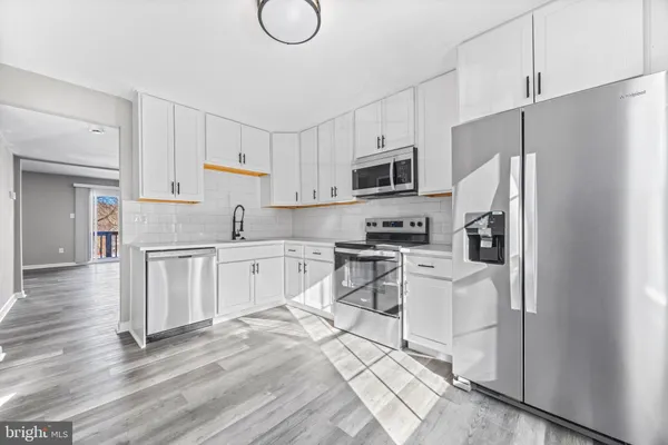 a kitchen with white cabinets and stainless steel appliances