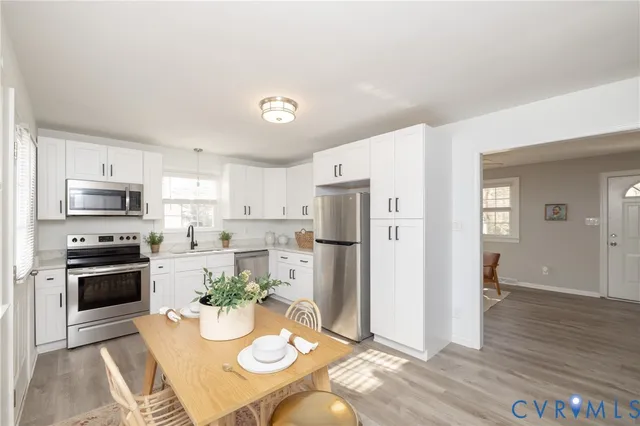 a open kitchen with stainless steel appliances a dining table and chairs