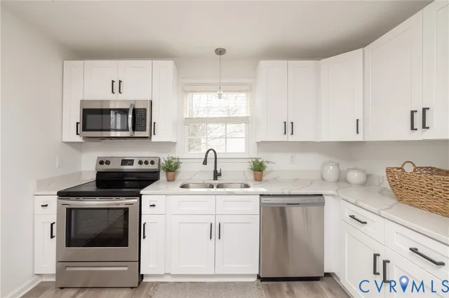 a kitchen with cabinets appliances a sink and a window