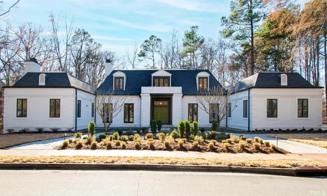 a front view of a house with swimming pool and outdoor seating