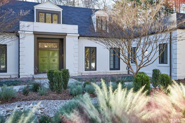 a dining room with wooden floor a chandelier a glass table and chairs