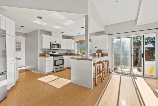 a open kitchen with stainless steel appliances granite countertop a sink and cabinets with wooden floor