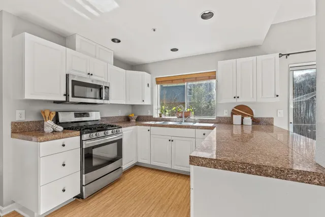 a living room with stainless steel appliances kitchen island granite countertop furniture and a kitchen view
