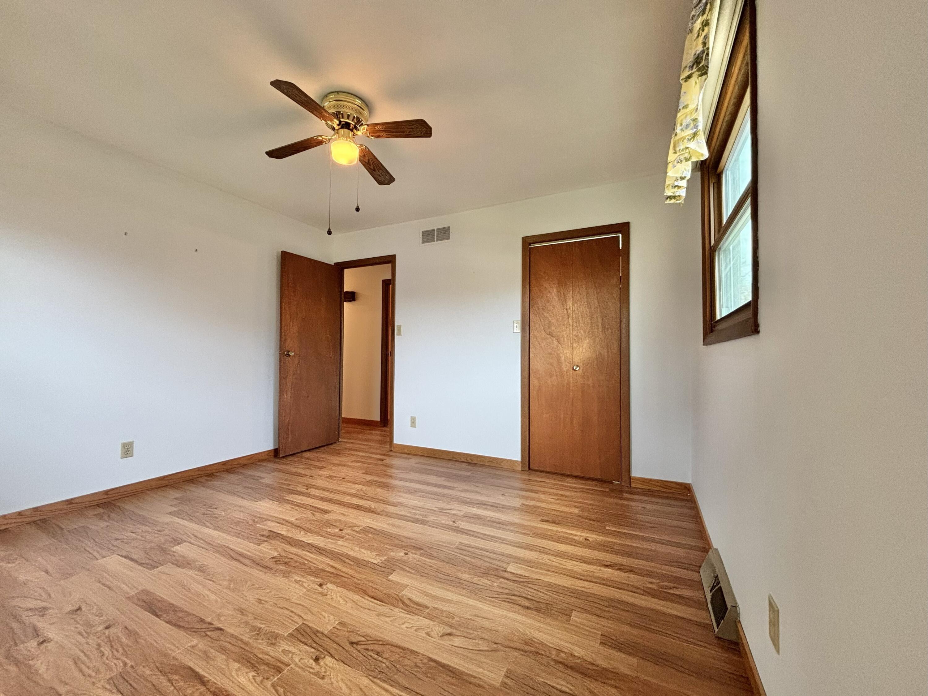 5361 Pierce Street Merrillville, IN 46410 - Photo 11 of 21 a view of an empty room with wooden floor and a ceiling fan