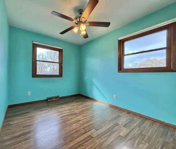 a view of a room with wooden floor and a window