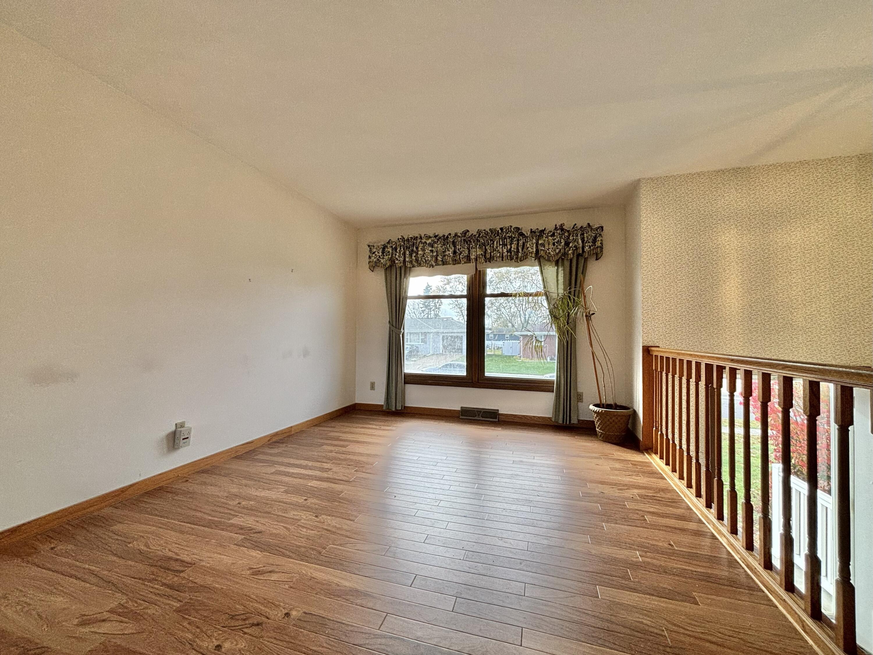 5361 Pierce Street Merrillville, IN 46410 - Photo 3 of 21 a view of an empty room with wooden floor and a window