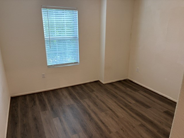 6917 Colorado Bluffs Road Austin, TX 78744 - Photo 14 of 19 a view of an empty room with wooden floor and a window