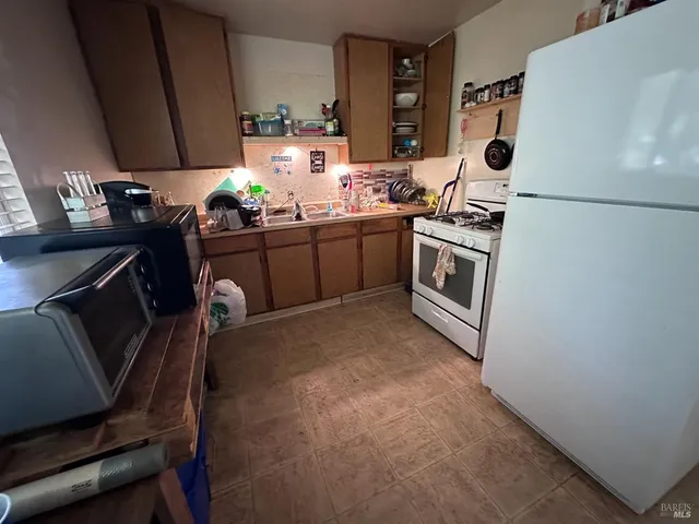 a kitchen with sink refrigerator and cabinets