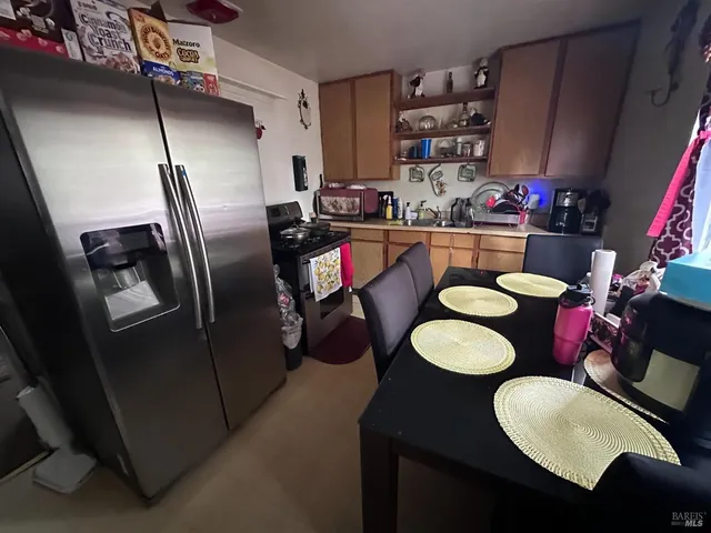 a kitchen with stainless steel appliances granite countertop a sink refrigerator and cabinets