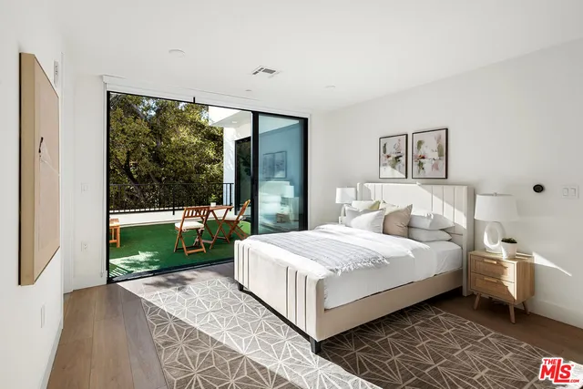 a bedroom with a bed and a large window with outer view