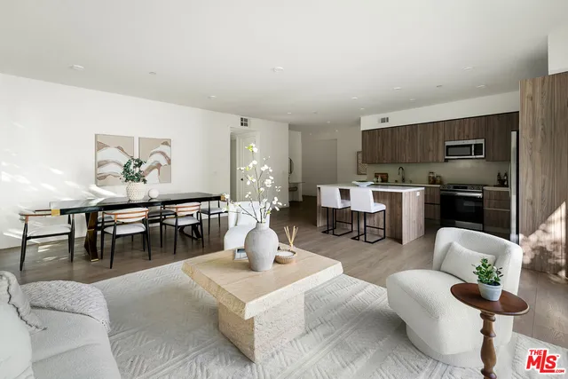 a living room with furniture a rug and a kitchen view