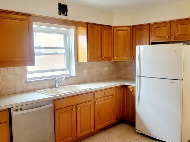 a kitchen with a refrigerator sink and cabinets