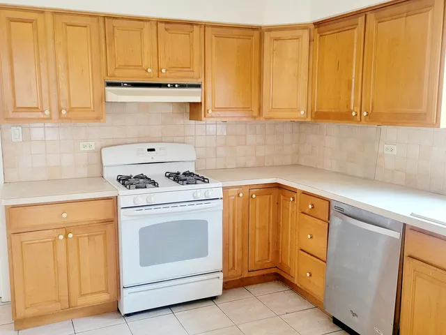 a kitchen with granite countertop white cabinets and white appliances