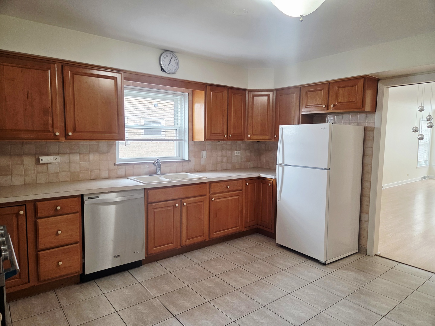 8537 West Foster Avenue, Unit 1 Chicago, IL 60656 - Photo 9 of 14 a kitchen with a refrigerator sink and cabinets