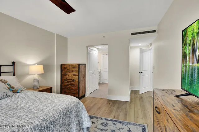 a spacious bedroom with a bed and a dresser in it