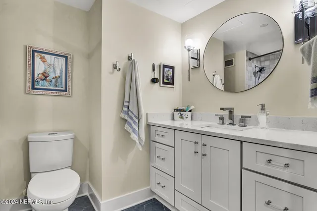 a spacious bathroom with a toilet a sink and mirror