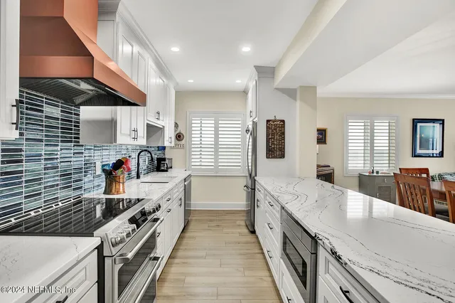 a large kitchen with stainless steel appliances granite countertop a lot of counter space and wooden floor
