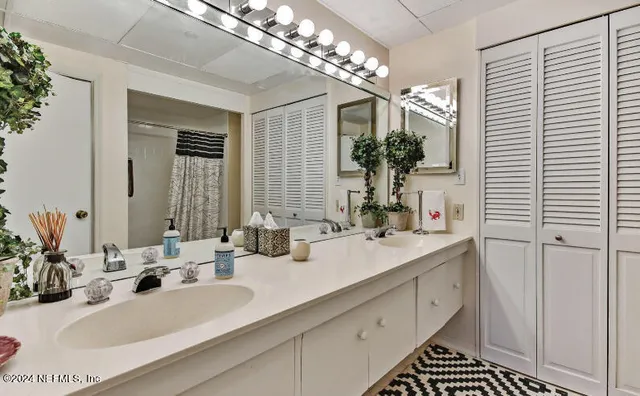 a bathroom with double vanity and a mirror