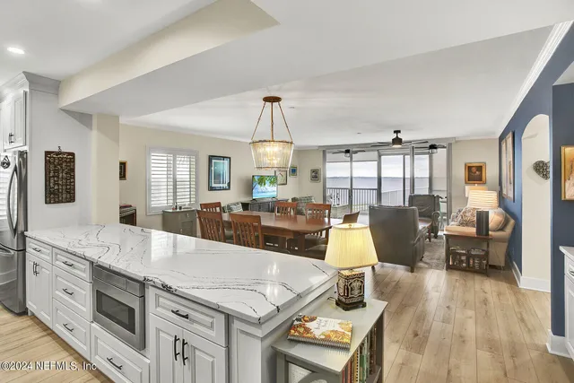 a large kitchen with kitchen island a stove a sink a dining table and chairs