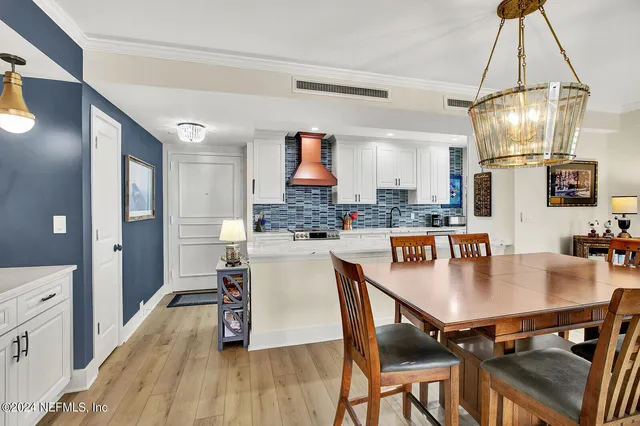 a kitchen with stainless steel appliances granite countertop a kitchen island a stove a table and chairs in it