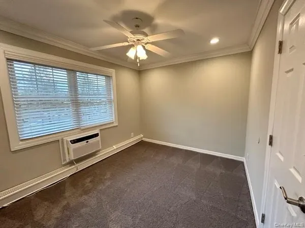 an empty room with windows and fan