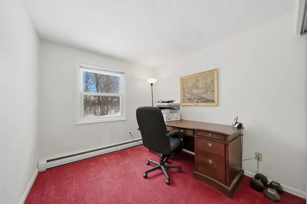 a view of a workspace with furniture and a window