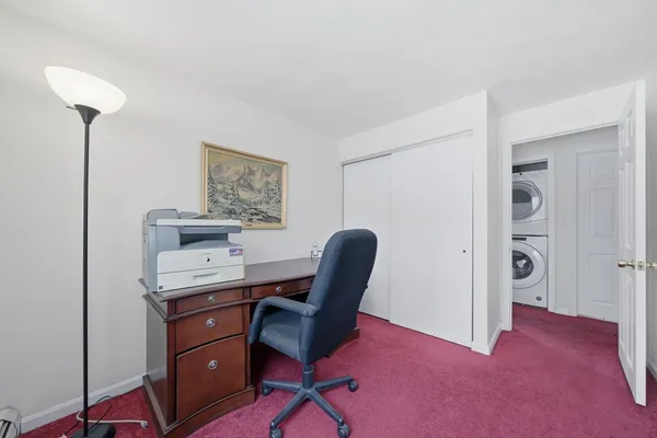 a view of a workspace with furniture and a window