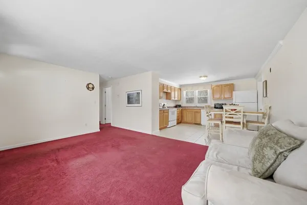 a living room with furniture and view of kitchen