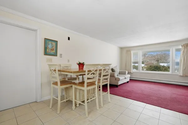 a dinning room with furniture and a large window