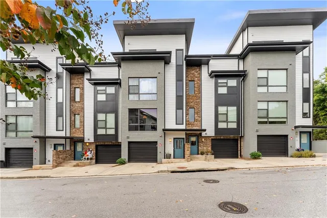 a kitchen with stainless steel appliances a table chairs refrigerator and wooden floor
