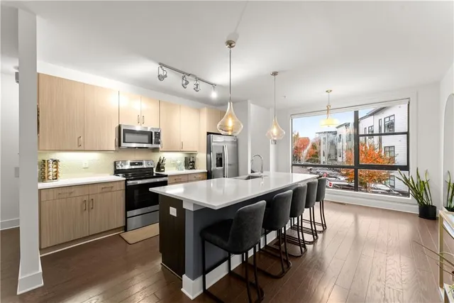 a kitchen with a stove a refrigerator a sink dishwasher with a dining table and chairs