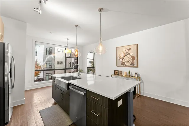 a large kitchen with sink a refrigerator and chairs