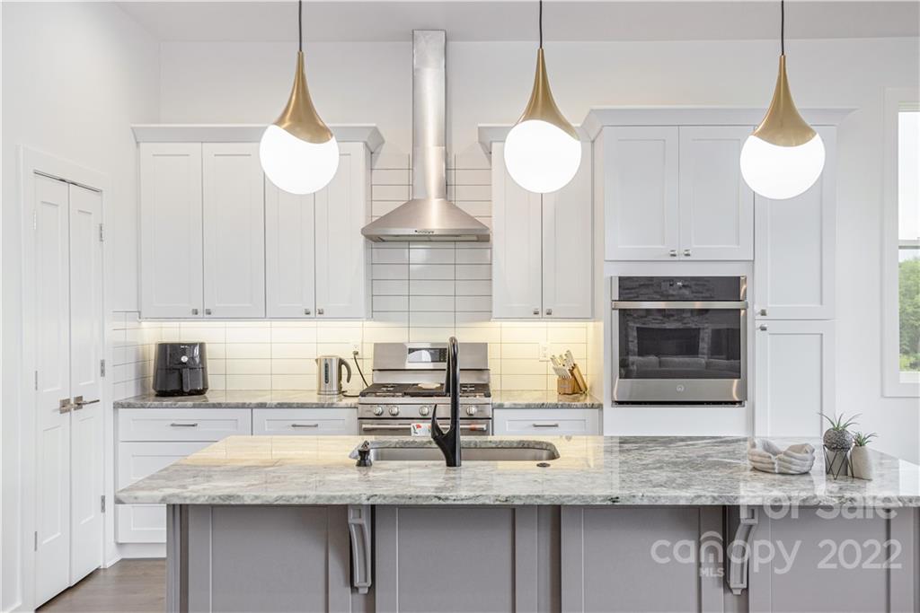 112 Meadow Breeze Road Arden, NC 28704 - Photo 12 of 44 a kitchen with stainless steel appliances granite countertop a sink a stove and a wooden floors