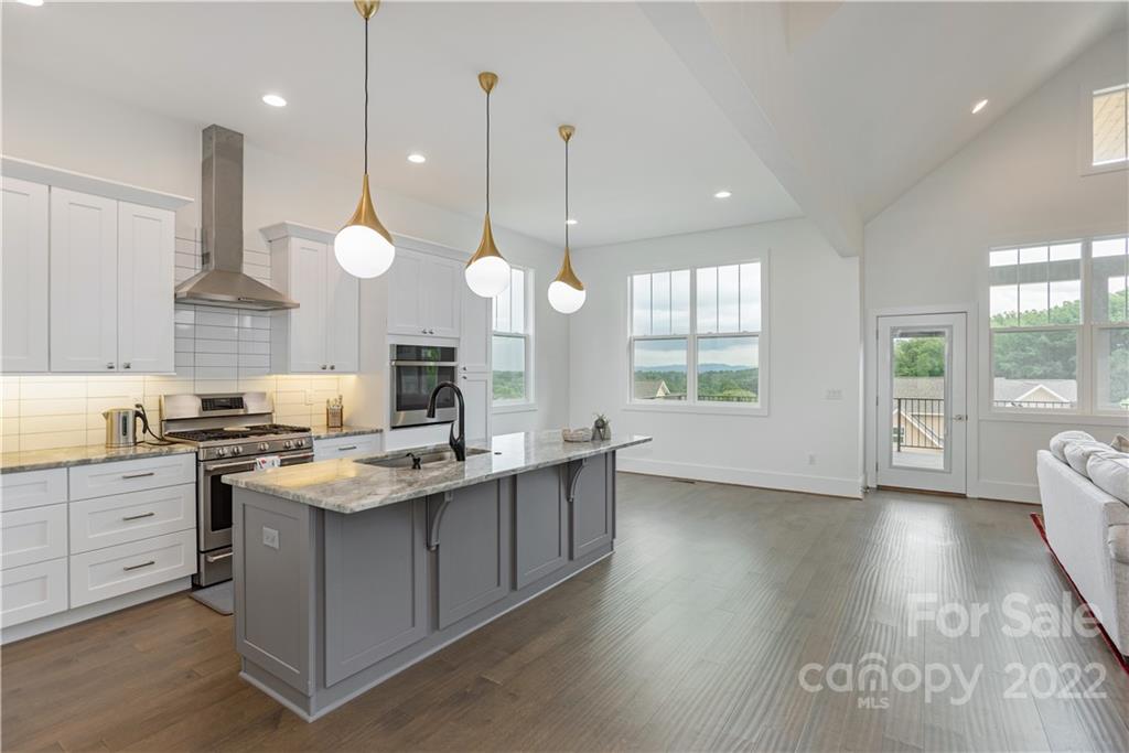 112 Meadow Breeze Road Arden, NC 28704 - Photo 15 of 44 a kitchen with a stove a sink a center island and a window